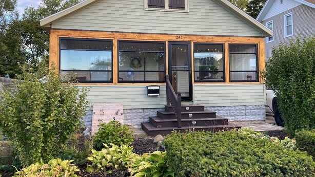 A house with a front porch, a mailbox, and a number 241 on the door.