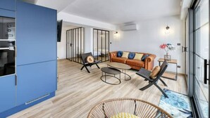 Una sala moderna con un sofá de cuero marrón, una mesa de centro y un sillón de mimbre.