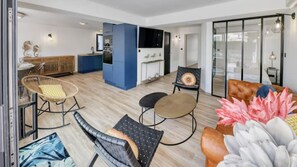 Un salon moderne comprenant un canapé, des fauteuils et un coin repas avec une table et des chaises.
