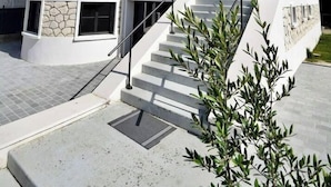 Un edificio moderno de varios pisos con una esquina curva, grandes ventanales y una escalera central.