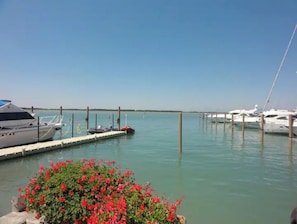 A marina with several yachts docked, calm water, and a clear sky. - Three-bedroom apartment in a beachfront condominium (Bibione)