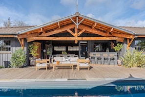 A wooden deck with outdoor seating and a pool.