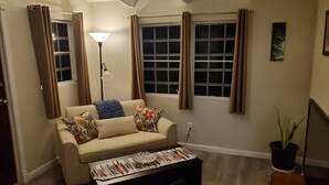 A living room with a sofa, a coffee table, a floor lamp, and a potted plant. - Villa Rose (Charlotte Amalie)
