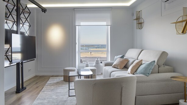 A modern living room with a sofa, ottomans, a coffee table, and a TV. - Always Easy I Sagües (San Sebastián/Donostia)