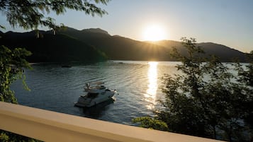 A boat on calm water with a sunset in the background.