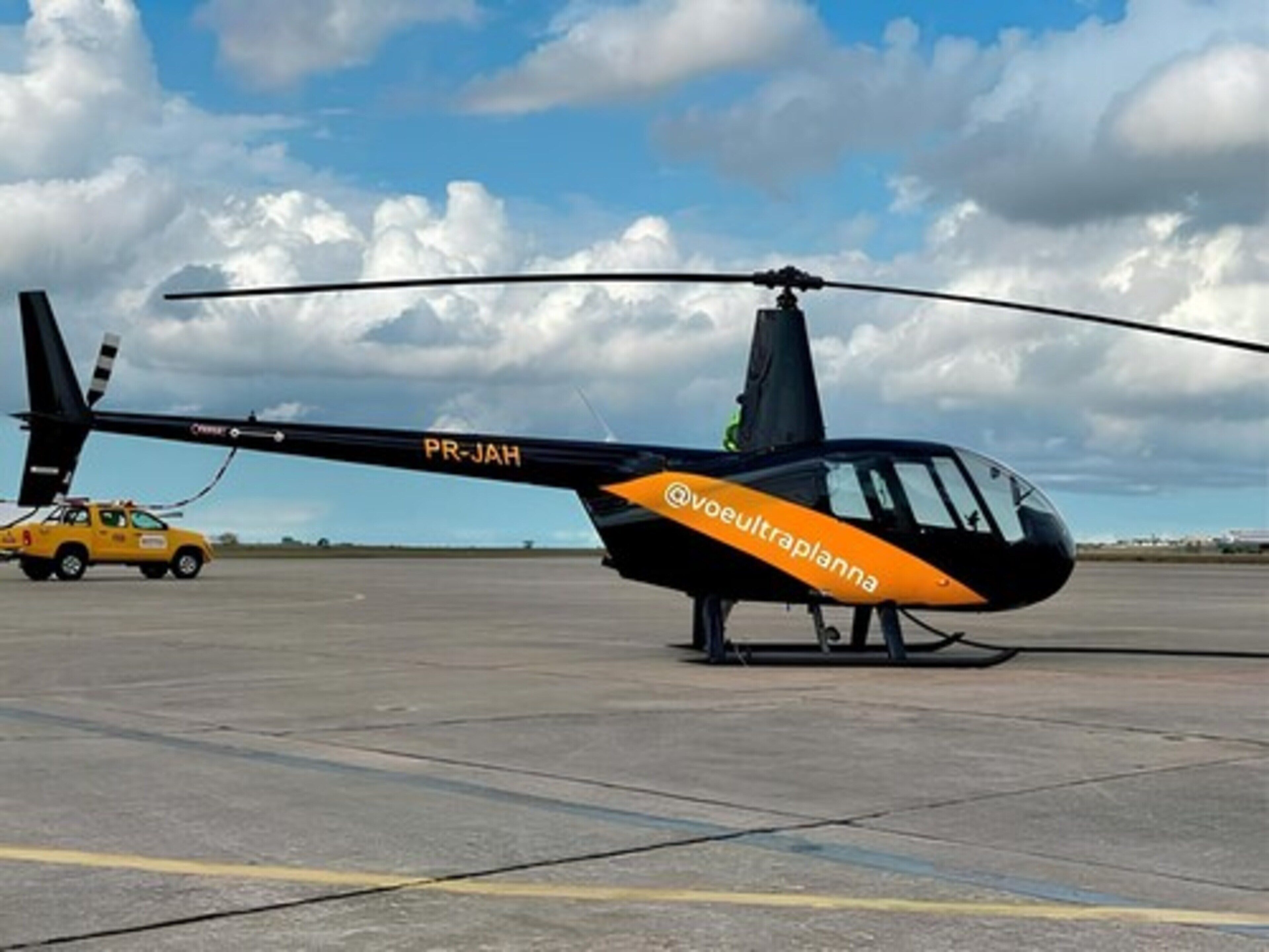 A helicopter with the registration PR-JAH parked on a tarmac.