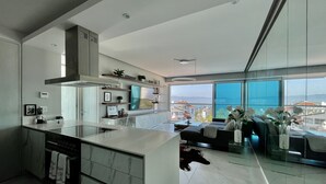 A modern kitchen with a large island, built-in appliances, and a view of the city through large windows. - Entire 2 Bedroom 2 Bath Marina Vallarta condo with insane view  (Puerto Vallarta)