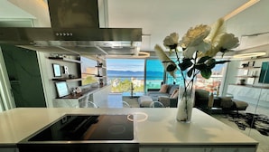 A modern kitchen with a built-in stove, oven, and a large window offering a view of the ocean. - Entire 2 Bedroom 2 Bath Marina Vallarta condo with insane view  (Puerto Vallarta)