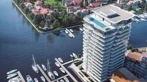 A high-rise hotel with multiple balconies, a rooftop pool, and a marina with boats. - Entire 2 Bedroom 2 Bath Marina Vallarta condo with insane view  (Puerto Vallarta)