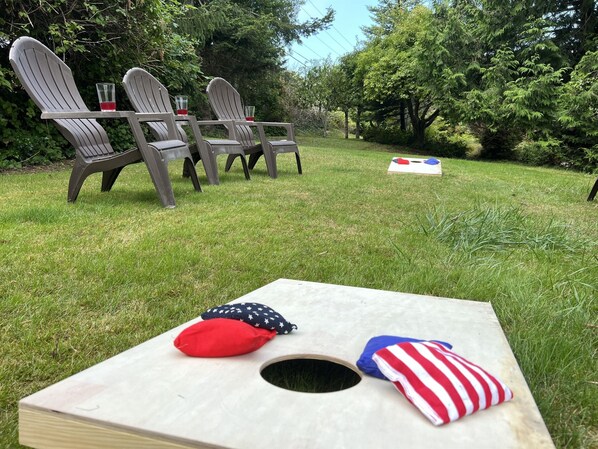 A wooden table with a hole in the center, surrounded by chairs and a small American flag pillow.