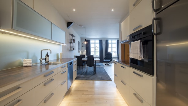 Una cocina moderna con electrodomésticos de acero inoxidable, encimeras de madera y un comedor con vistas al exterior.