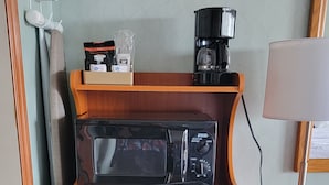 A compact kitchenette with a microwave, coffee maker, and a small refrigerator. - Downtown Inn #3- King Room (Asheville)