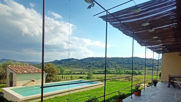 Zona de piscina con vistas a un paisaje verde y colinas.