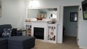 A living room with a fireplace, a sofa, and a bookshelf. - RIVER FRONT RELAXATION (Chillicothe)