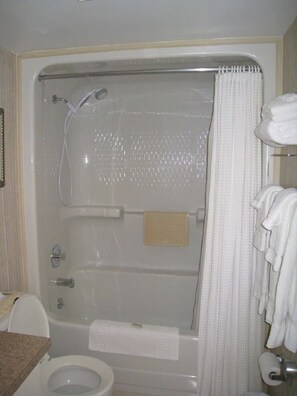 Une salle de bain avec une baignoire, des toilettes et un rideau de douche.