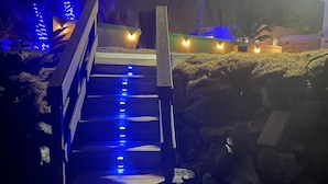 A wooden staircase leading up to a building, surrounded by rocks and illuminated by blue lights. - NEW LISTING! OCEAN FRONT AND RAINFOREST 16 GUESTS (Río Grande)