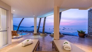 A serene spa area with two sun loungers, a small pool, and a view of the sea at dusk. - Your exclusive villa on the sand, Private Pool, Stunning Ocean Views (Tambon Patong, Amphoe Kathu)