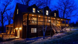 A two-story log cabin with a balcony, large windows, and a covered porch area. - Covered Hot Tub, Great Games, Near Thunder Bay Falls / With Owners' Club Access (Galena)