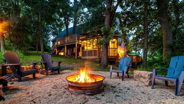 A rustic cabin with a fire pit and Adirondack chairs in a forest setting. - Covered Hot Tub, Great Games, Near Thunder Bay Falls / With Owners' Club Access (Galena)