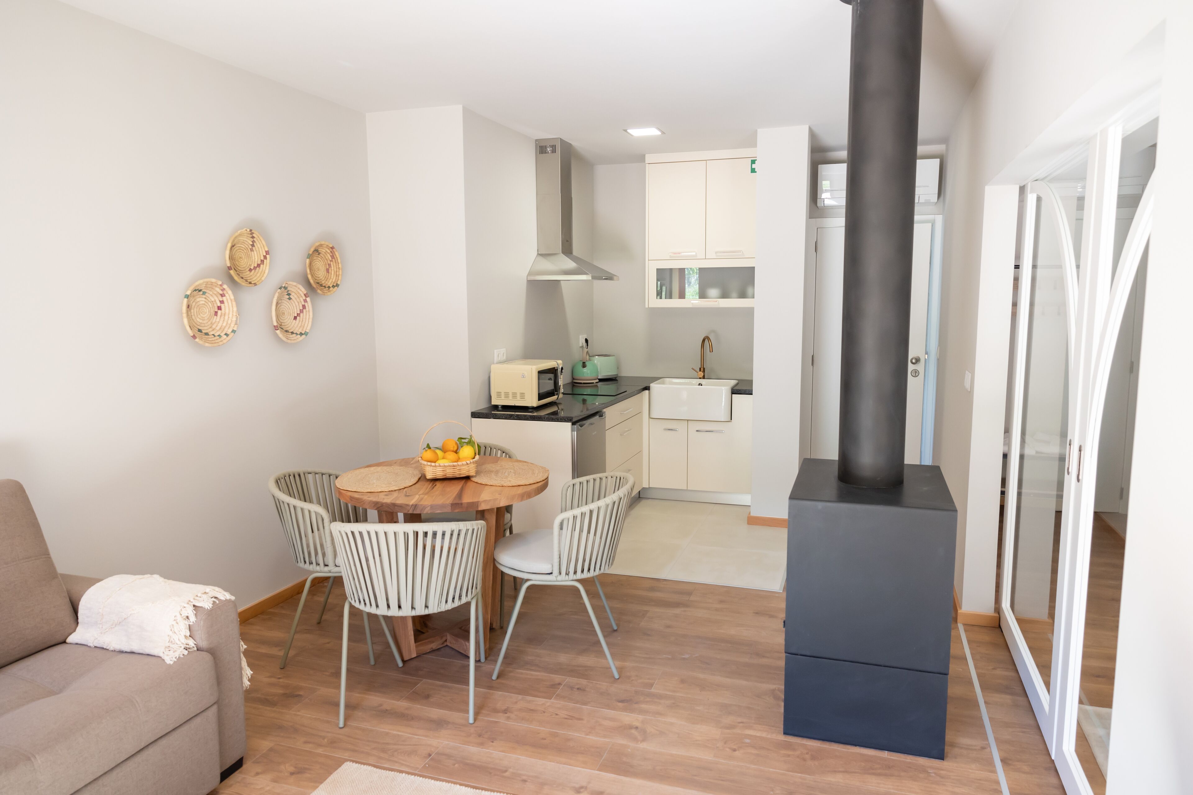 A modern kitchen with a central island, white cabinetry, and a black stove.