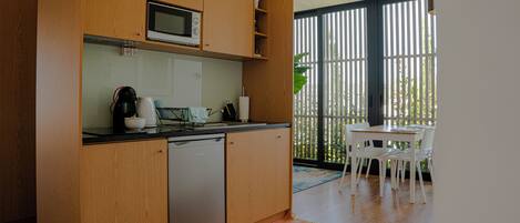 Una cocina compacta con armarios de madera, lavavajillas y microondas.