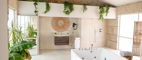 A modern bathroom with a freestanding bathtub, a vanity with a mirror, and a large window providing natural light.