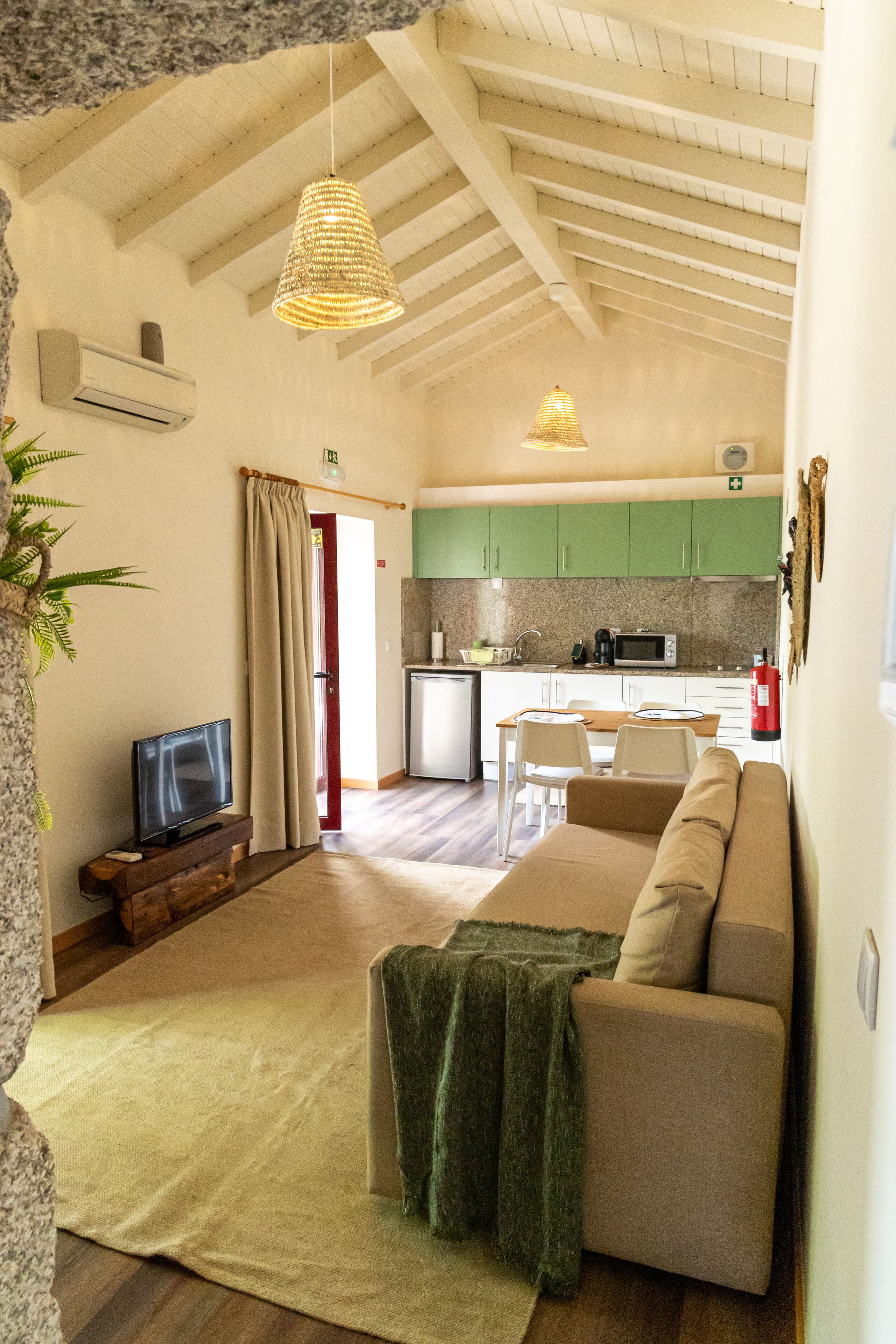 Una sala de estar con sofá, televisión y un comedor con mesa y sillas.