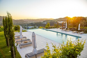 Una piscina cubierta, una piscina al aire libre, tumbonas