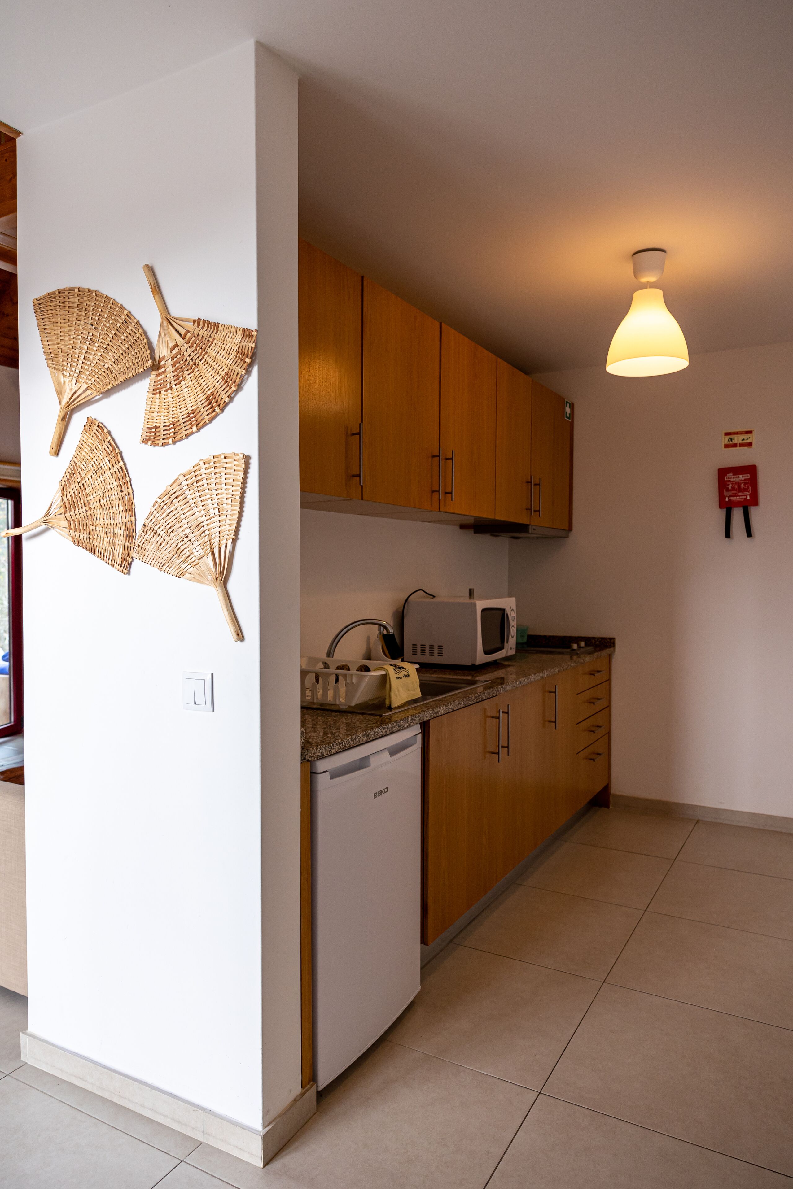 Una cucina con mobili in legno, un forno a microonde ed una lavastoviglie.