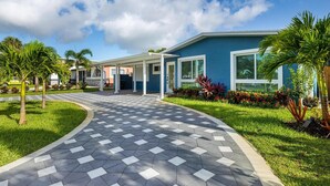 A modern building with a covered entrance, a paved walkway, and well-maintained landscaping.