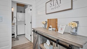 A hotel reception area with a wooden reception desk, a 'STAY' sign, a no-smoking sign, and a small vase with flowers. - Romantic Cabin - Lakeside (Jonesburg)