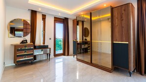 A modern bedroom with a large mirror, a wardrobe, and a sliding door leading to a balcony. - Alanya Luxury Villas (Alanya)