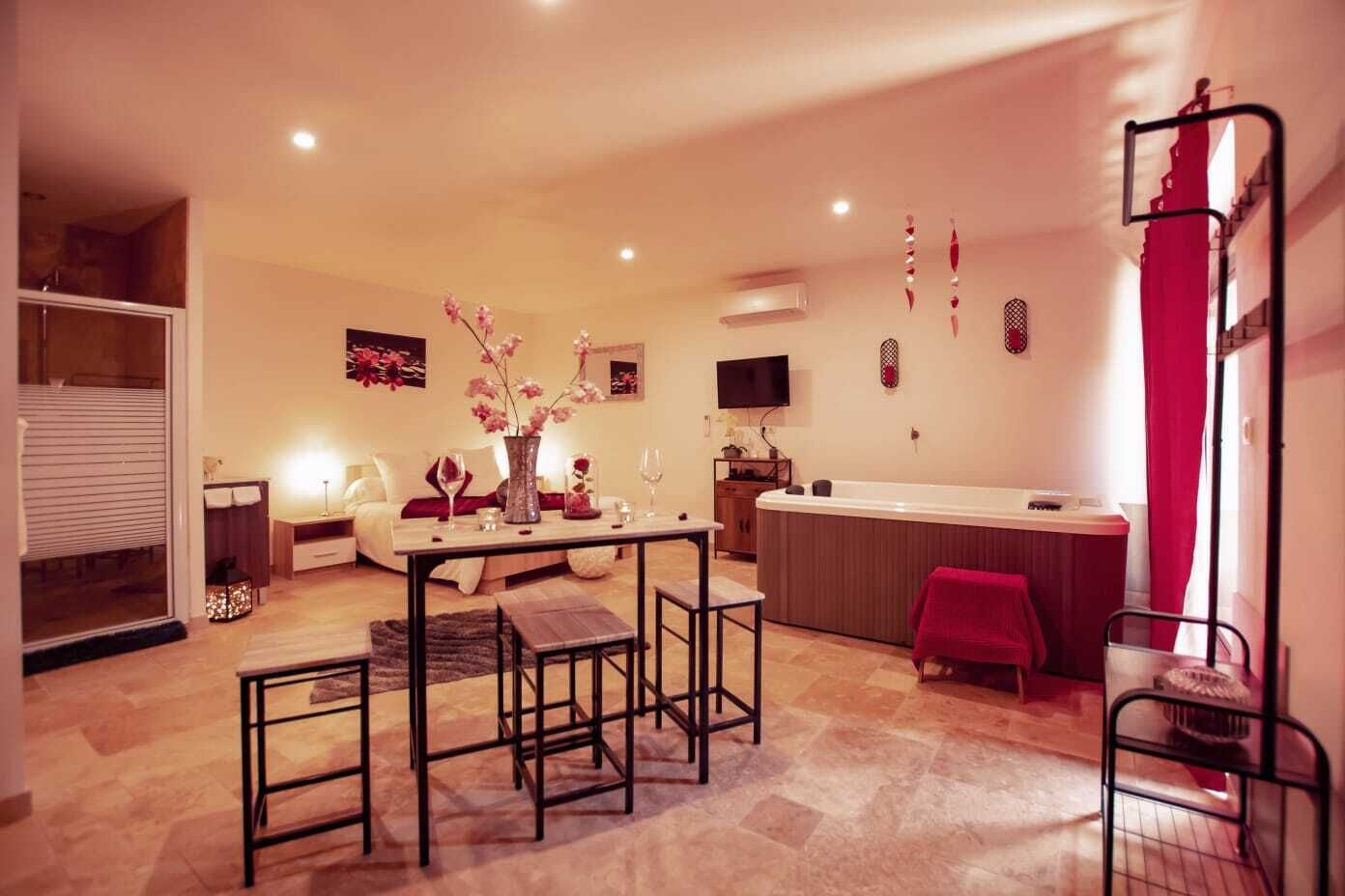 Ein modernes Wohnzimmer mit Essbereich, einem großen Fenster und einem roten Vorhang.