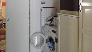 Ein Waschraum mit Waschmaschine, Trockner und Wäscheständer.