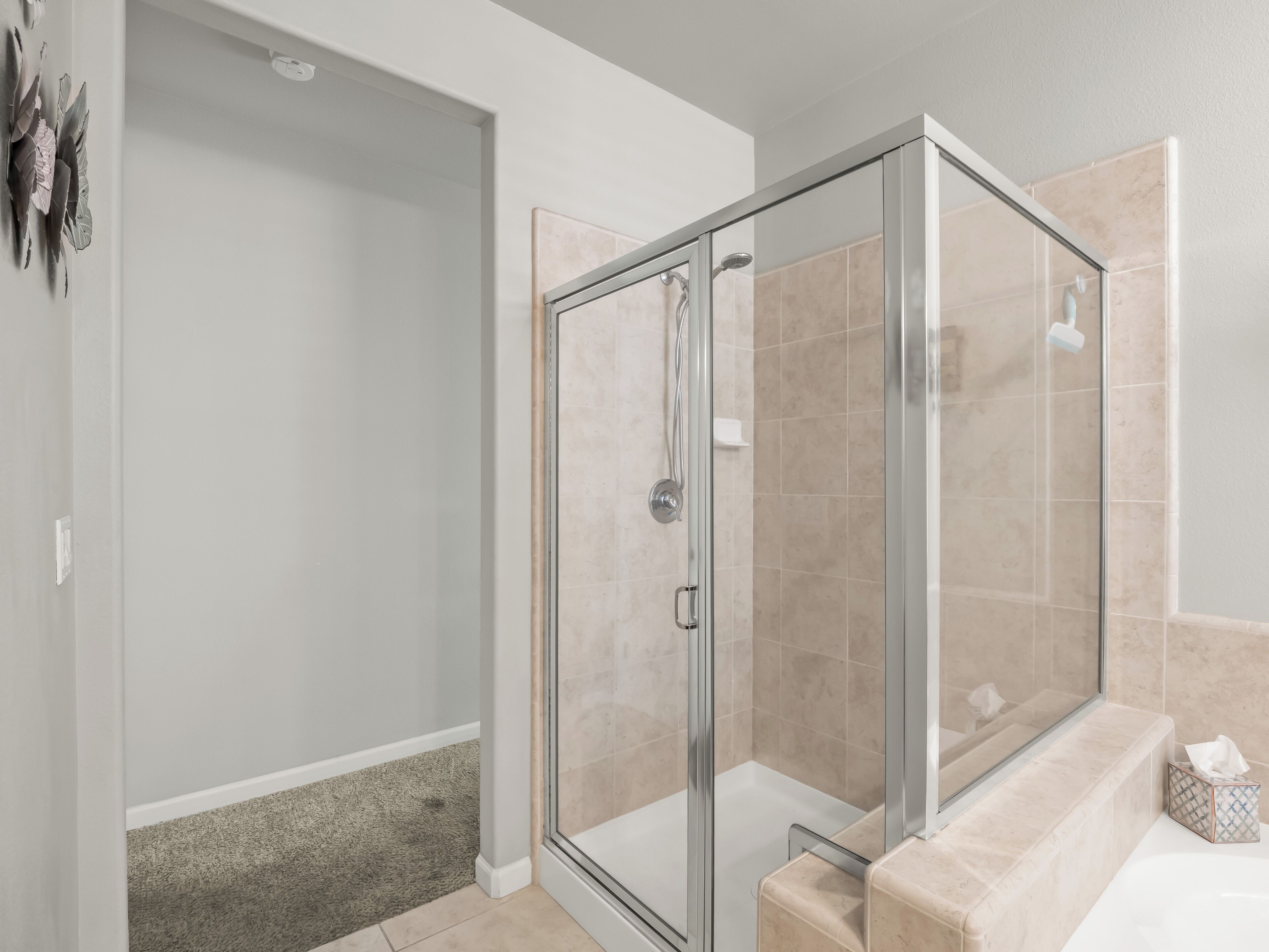 Een moderne badkamer met een douchecabine van glas, een bad en een toilet.