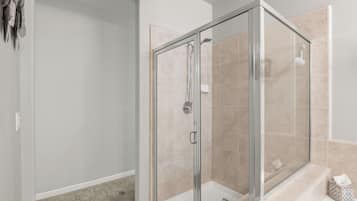 Een moderne badkamer met een douchecabine van glas, een bad en een toilet.