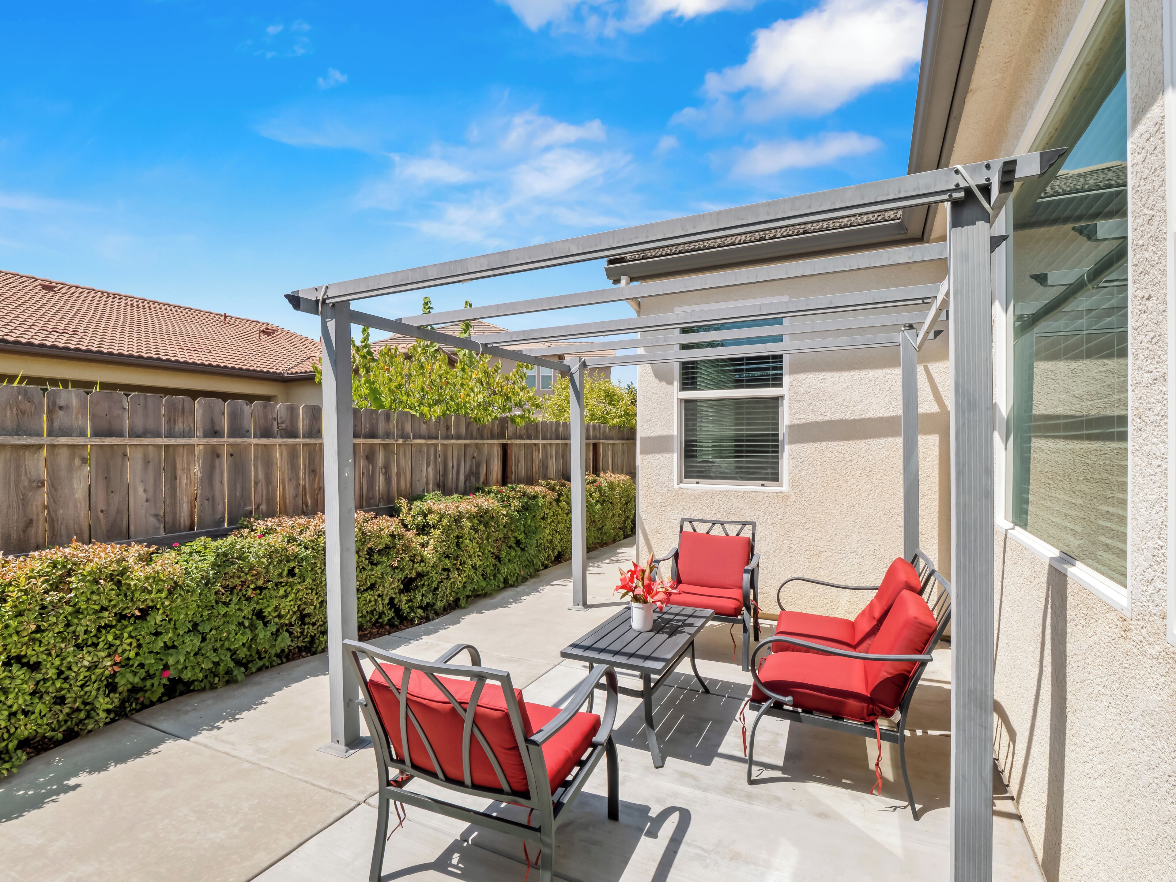 A covered patio area with outdoor furniture and a pergola structure.