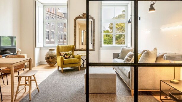 Una sala de estar moderna con un sofá, un sillón y un televisor.