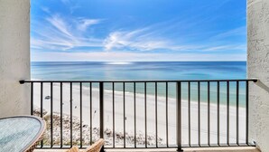 Ein Balkon mit Blick auf Strand und Meer.