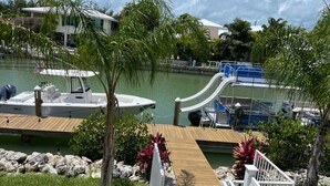 Un puerto deportivo con barcos amarrados, una cubierta de madera y un tobogán.