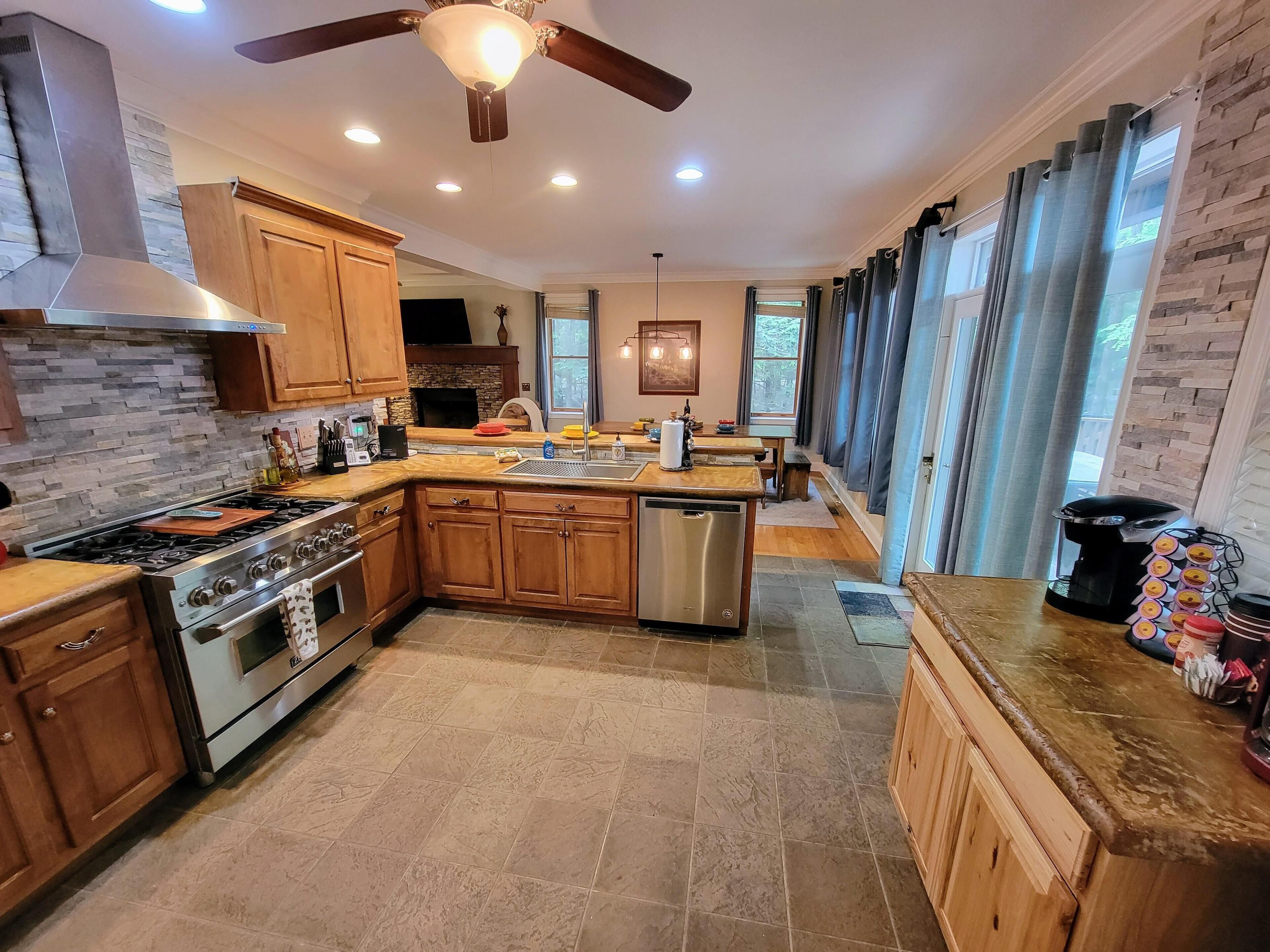 Una cocina moderna con armarios de madera, una isla central, una estufa y un lavavajillas.