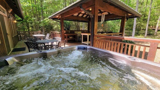 Ein Whirlpoolbereich mit Holzterrasse und Sitzgelegenheiten im Freien.