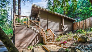 Une maison en bois avec un escalier en bois menant à une terrasse.