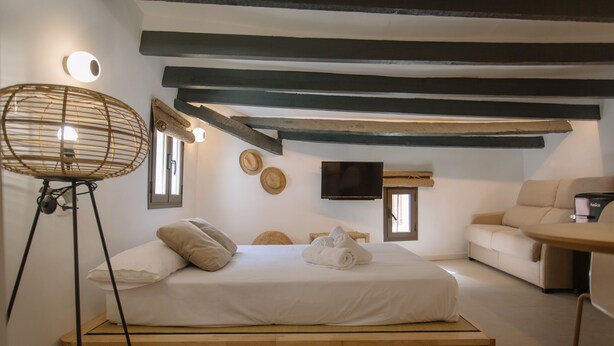 A bedroom with a bed, a chair, a TV, and a small table. - Alojamientos La Vila Mayor 36 (Villajoyosa)