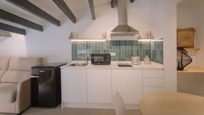 A compact kitchen with a built-in microwave, a sink, and a compact refrigerator. - Alojamientos La Vila Mayor 36 (Villajoyosa)