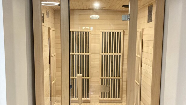 Eine Sauna mit Holzlamellen und einer Bank.