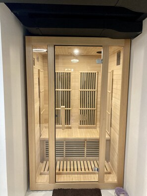 A sauna with wooden slats and a bench.