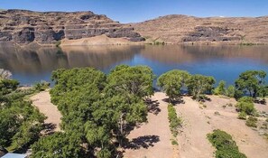 A campsite with tents, a lake, and rocky hills.