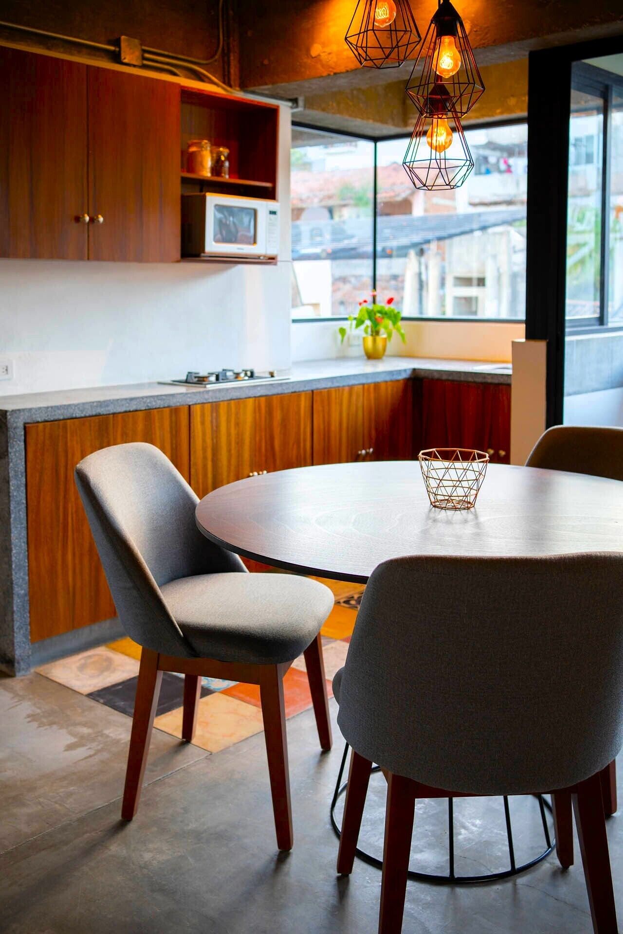 A modern kitchen with wooden cabinets, a round dining table, and two chairs.