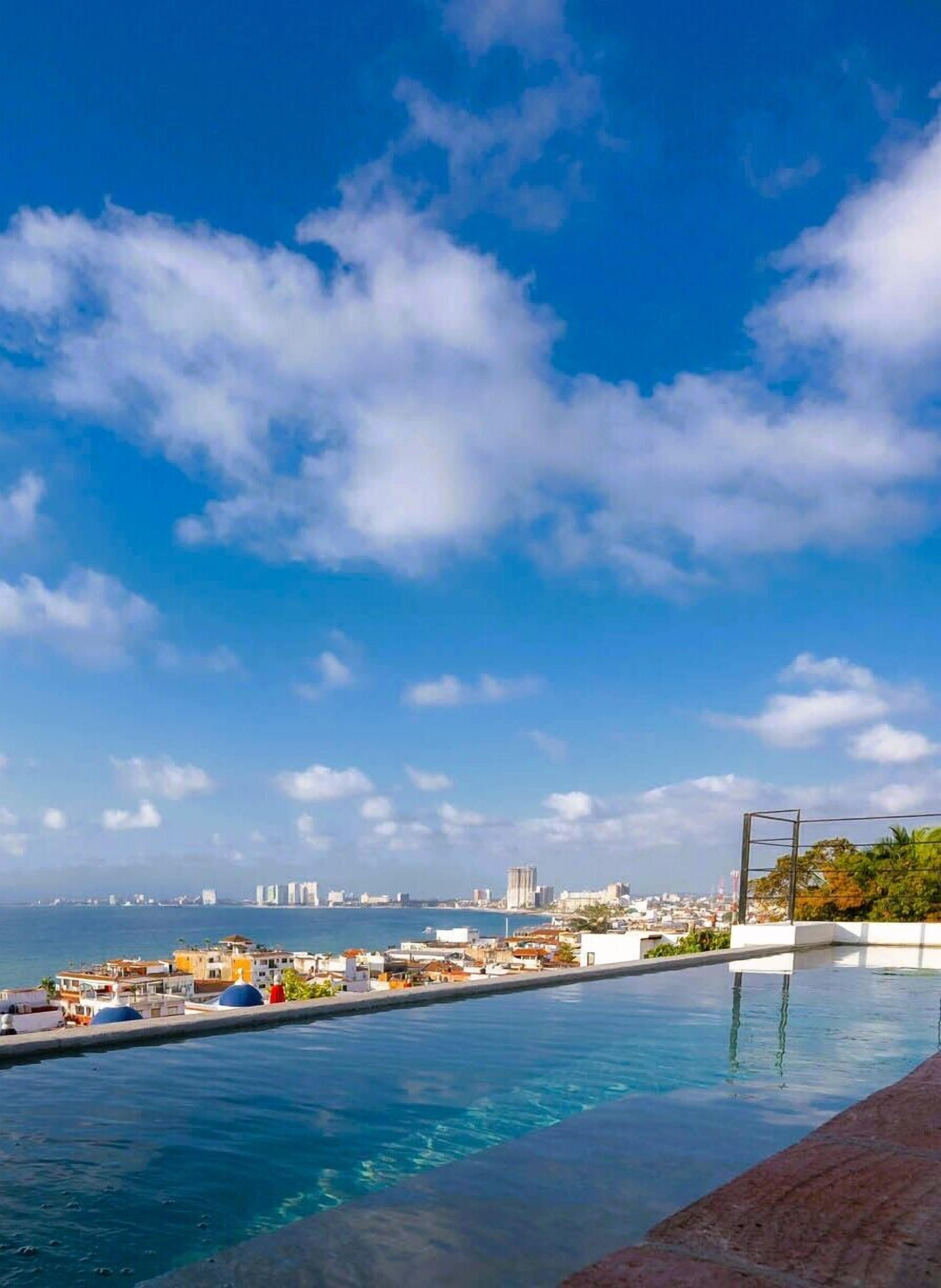 A swimming pool with a cityscape view, including buildings and a clear sky.